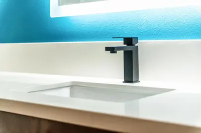 a sink with a faucet in a bathroom at Aspire Inn Studios & Spas in Bellflower