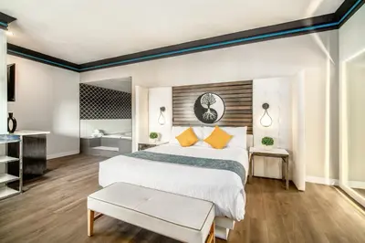 a bedroom with a large bed and a bathroom at Aspire Inn Studios & Spas in Bellflower