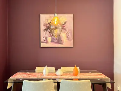 a dining room table with chairs and a painting on the wall at Hollywood Purple Habitat in Los Angeles