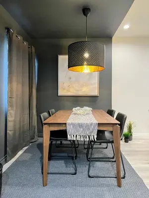 a dining room with a wooden table and a lamp at Hollywood Black Habitat in Los Angeles