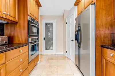 a kitchen with wooden cabinets and a refrigerator at Rivo of Dreams in Long Beach