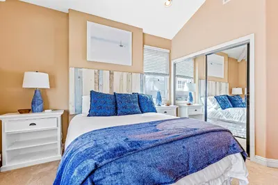 a bedroom with a large bed with blue pillows at Rivo of Dreams in Long Beach