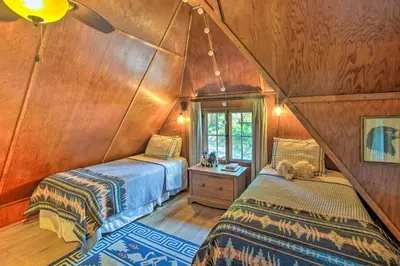 a bedroom with two beds in a room with wooden walls at Vintage Lake Arrowhead Cabin - Walk to Lake! in Lake Arrowhead