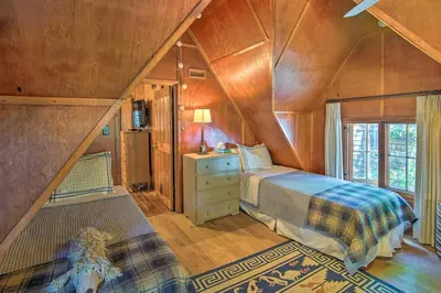 a bedroom with a bed in a wooden room at Vintage Lake Arrowhead Cabin - Walk to Lake! in Lake Arrowhead