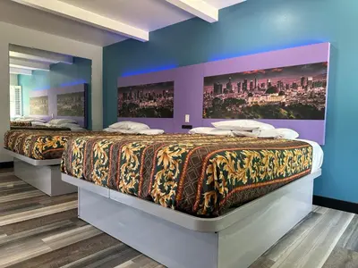 two beds in a room with blue walls at Fountain Inn Motel - Alhambra, Los Angeles in Alhambra
