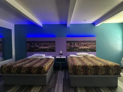 two beds in a room with blue walls at Fountain Inn Motel - Alhambra, Los Angeles in Alhambra