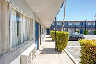 a sidewalk in front of a building with a car at ERTH INN by AGA- Mojave in Mojave