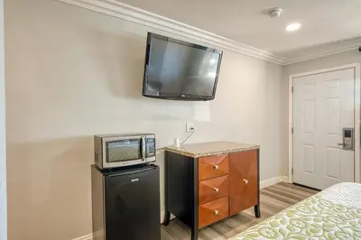 a room with a tv on the wall and a bed at ERTH INN by AGA- Mojave in Mojave