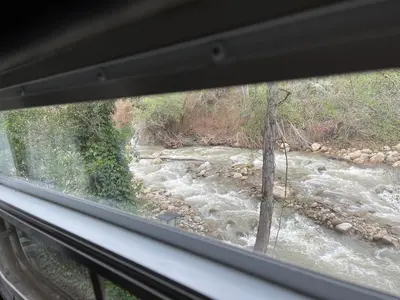 a view of a river from a window at Vintage RV Creekside Nature Retreat near Ojai next to Swim Holes Hike in Santa Paula