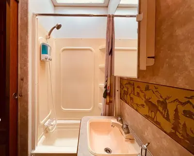 a small bathroom with a sink and a shower at Vintage RV Creekside Nature Retreat near Ojai next to Swim Holes Hike in Santa Paula