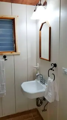 a bathroom with a white sink and a mirror at Redwood Retreat, Mountains, Adventure and Nature in Ponderosa