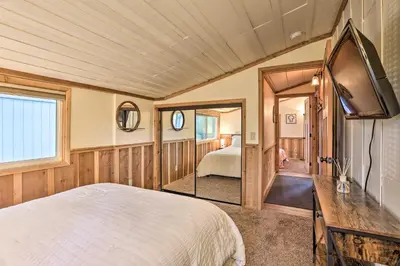 a bedroom with a bed and a tv in it at Walk to Big Bear Lake Cozy Cabin with Deck in Big Bear Lake
