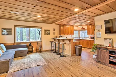 a living room with a couch and a kitchen at Walk to Big Bear Lake Cozy Cabin with Deck in Big Bear Lake