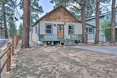 a house with a porch and a fence at Walk to Big Bear Lake Cozy Cabin with Deck in Big Bear Lake