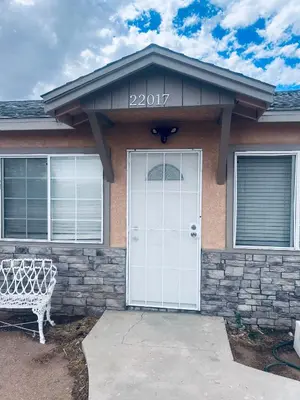 a house with a white door and a bench at Sky Fresh Home Stay in Apple Valley