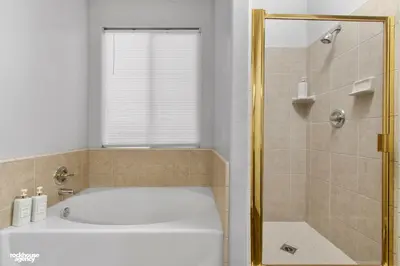a bathroom with a tub and a shower with a window at NorthWest Farmhouse in Bakersfield
