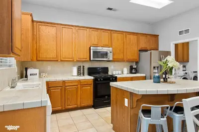 a kitchen with wooden cabinets and a counter top at NorthWest Farmhouse in Bakersfield