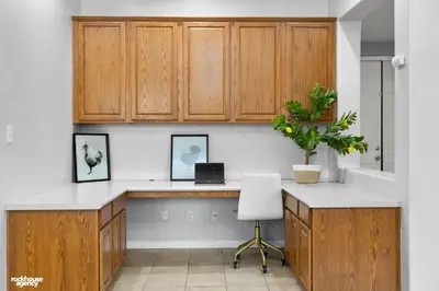 a kitchen with wooden cabinets and a laptop on a counter at NorthWest Farmhouse in Bakersfield
