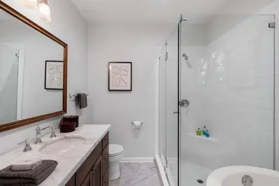 a white bathroom with a shower and a sink at Secluded 4BR Spanish Oasis in the Heart of LA in Los Angeles