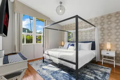 a bedroom with a canopy bed and a window at Beach Villa * Hot Tub * Steps to Beach in Long Beach