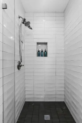 a bathroom with three blue bottles in a shower at Beach Villa * Hot Tub * Steps to Beach in Long Beach