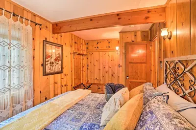 a bedroom with a bed in a room with wooden walls at Wrightwood Cabin with Cozy Interior! in Wrightwood