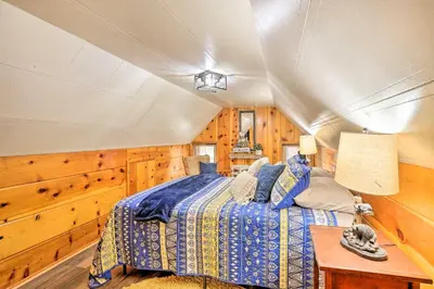 a bedroom with a bed in a room with wooden walls at Wrightwood Cabin with Cozy Interior! in Wrightwood