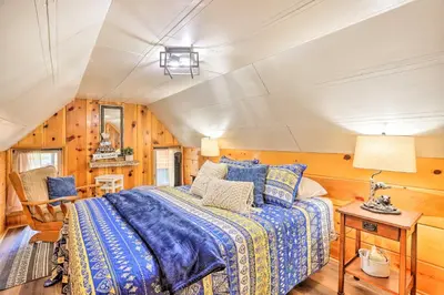 a bedroom with a bed in a room with wooden walls at Wrightwood Cabin with Cozy Interior! in Wrightwood