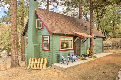 a green tiny house with two chairs and a table at Wrightwood Cabin with Cozy Interior! in Wrightwood