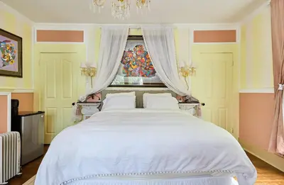a bedroom with a large white bed with a window at Hollywood Home in Los Angeles