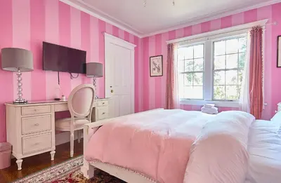 a pink bedroom with a bed and a desk at Hollywood Home in Los Angeles