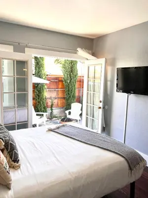 a bedroom with a large bed and a patio at Hollywood house with parking - walk to attractions in Los Angeles