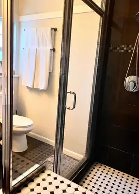 a bathroom with a shower with a toilet and towels at Hollywood house with parking - walk to attractions in Los Angeles