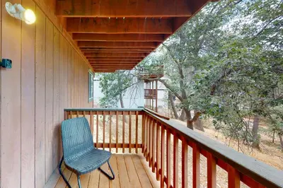 a porch with a blue chair on a wooden deck at Sequoia Serenity in Lake Arrowhead