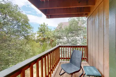 a balcony with a chair and a view of trees at Sequoia Serenity in Lake Arrowhead