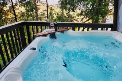a hot tub with a bottle of wine in it at Lakeside Serenity in Crestline