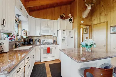 a kitchen with white cabinets and white appliances at Lakeside Serenity in Crestline