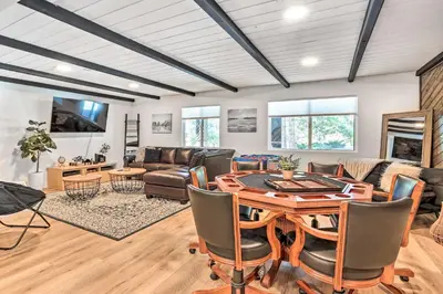 a living room with a table and a couch at Luxe Timberland Villa with Lake Arrowhead Access! in Lake Arrowhead