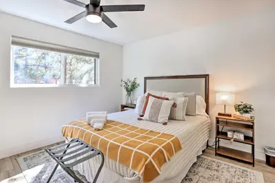 a bedroom with a large bed with a ceiling fan at Luxe Timberland Villa with Lake Arrowhead Access! in Lake Arrowhead