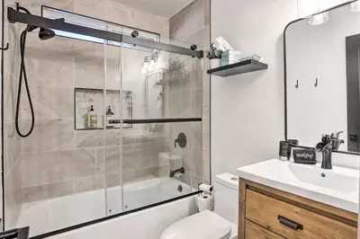 a bathroom with a shower and a toilet and a sink at Luxe Timberland Villa with Lake Arrowhead Access! in Lake Arrowhead