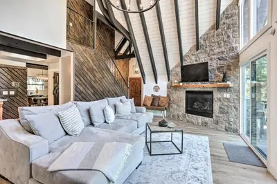 a living room with a couch and a fireplace at Luxe Timberland Villa with Lake Arrowhead Access! in Lake Arrowhead