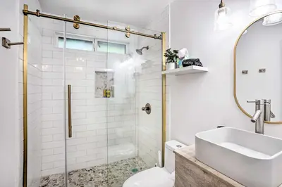 a bathroom with a glass shower stall and a sink at Luxe Timberland Villa with Lake Arrowhead Access! in Lake Arrowhead