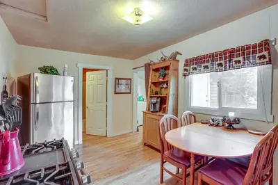 a kitchen with a table and a refrigerator at Grizzly Pine Cottage - Walk to Ski Beach Park! in Big Bear Lake