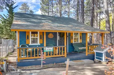 a blue and yellow tiny house with a porch at Grizzly Pine Cottage - Walk to Ski Beach Park! in Big Bear Lake