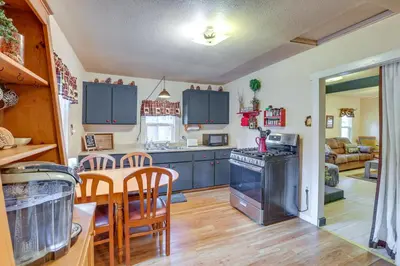 a kitchen and living room with a table and chairs at Grizzly Pine Cottage - Walk to Ski Beach Park! in Big Bear Lake