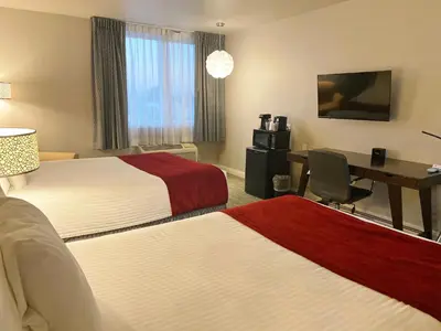 a hotel room with two beds and a desk at Redac Gateway Hotel Torrance in Torrance