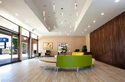 a lobby with a green table and yellow chairs at Redac Gateway Hotel Torrance in Torrance