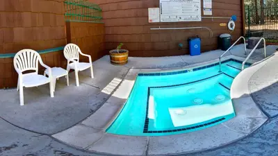 a swimming pool with two chairs and a table at GetAways at Snow Lake Lodge in Big Bear Lake