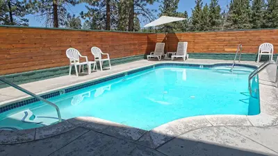 a swimming pool with chairs and a table at GetAways at Snow Lake Lodge in Big Bear Lake