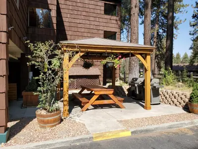 a picnic shelter with a picnic table in front of a house at GetAways at Snow Lake Lodge in Big Bear Lake